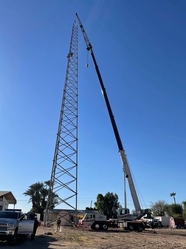 100 ton truck crane with jib assembling a radio tower.