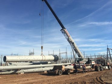 100 ton truck crane loading steel utility pole.