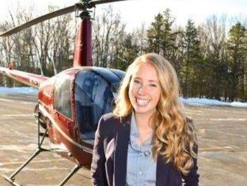 Heather Howley in front of R22 helicopter