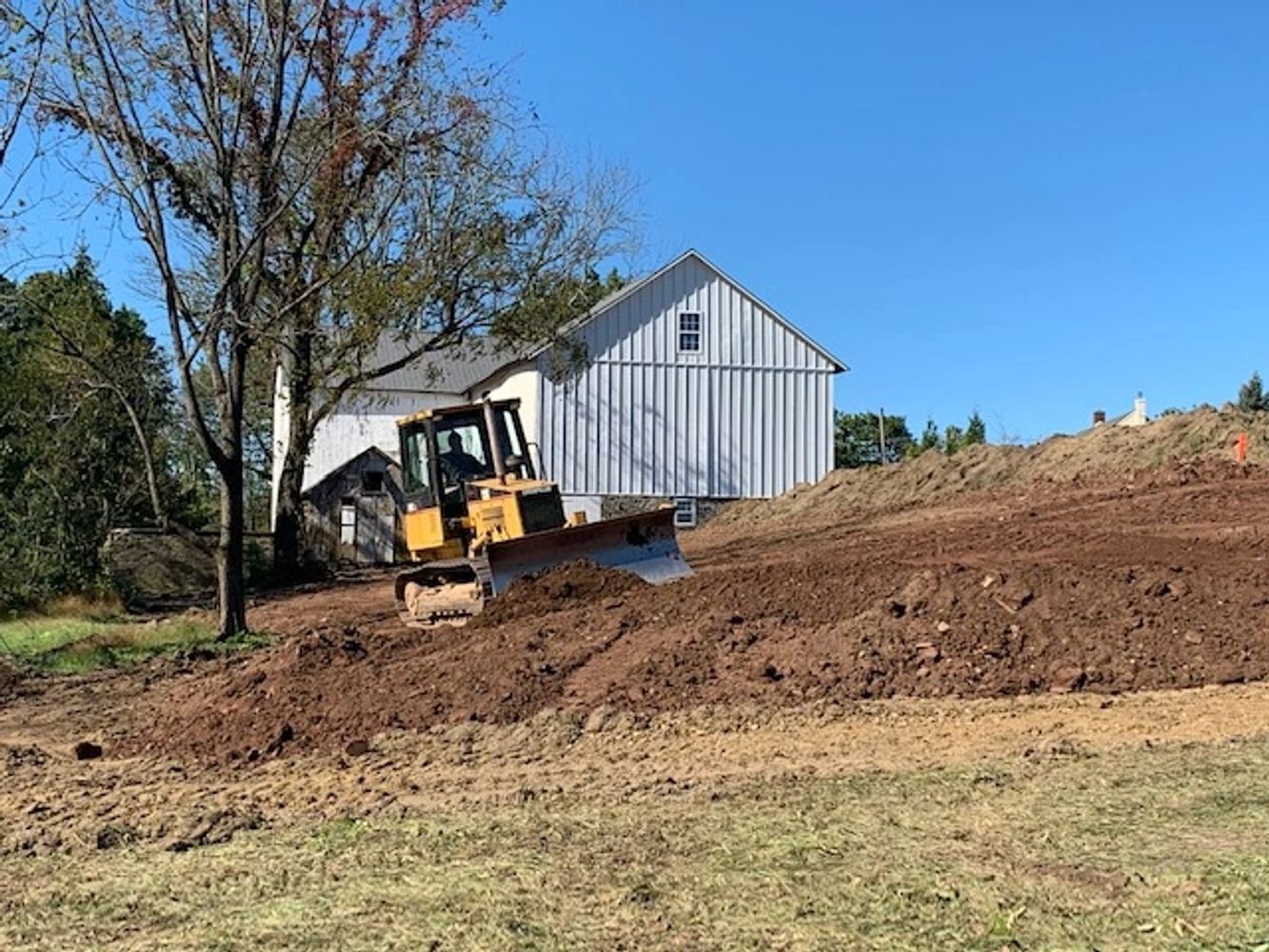 Grading of an existing lot to repair drainage issues.