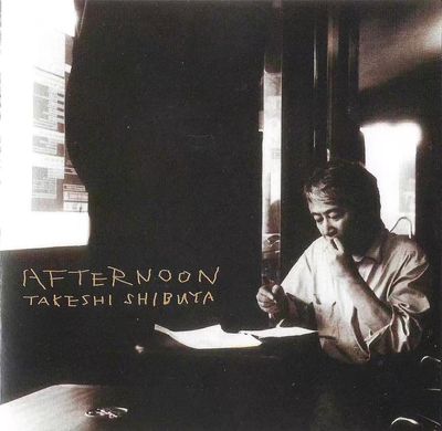 Man reading and writing in a dimly lit room.