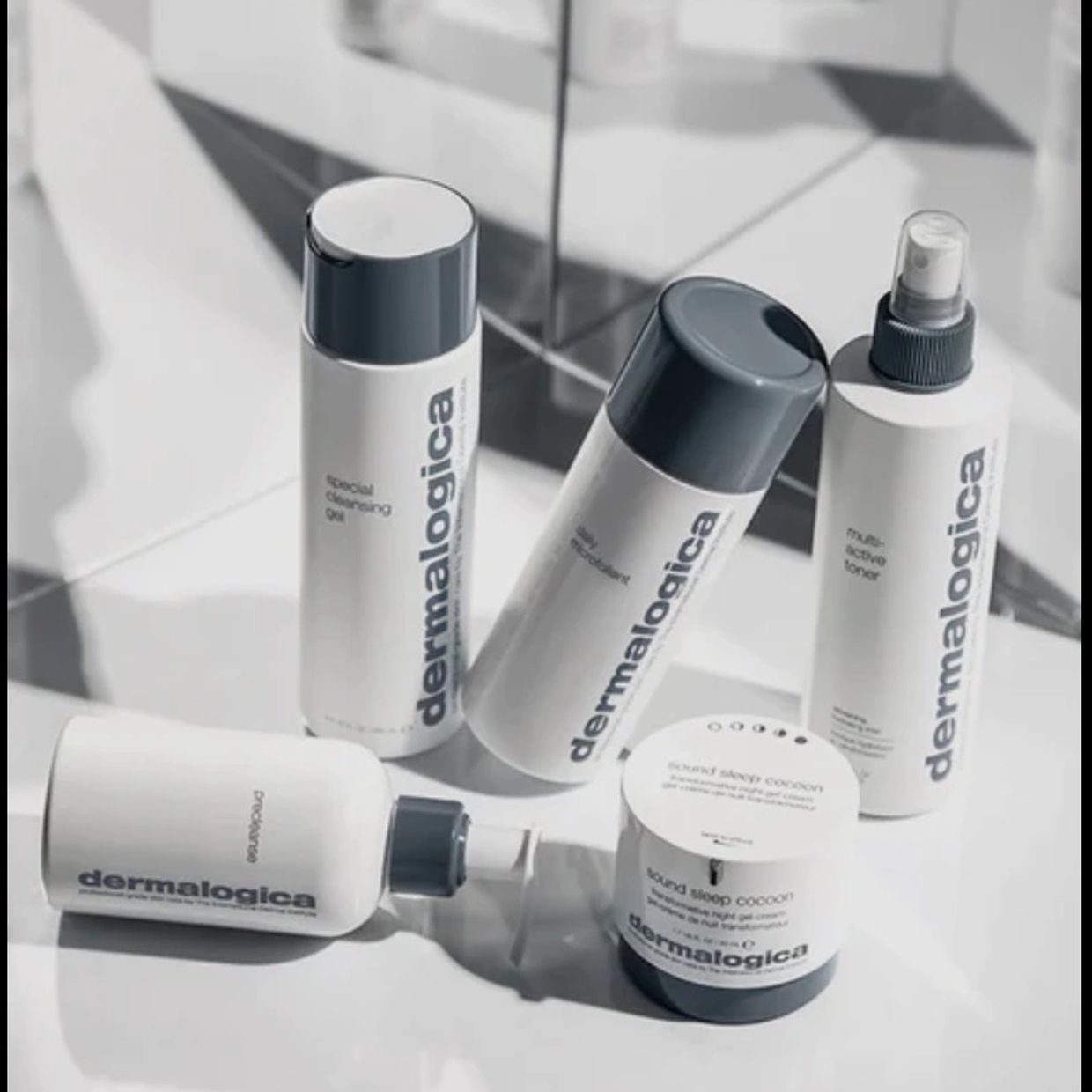 Dermalogica skincare products arranged on a reflective surface.