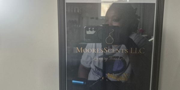 Glass plaque for MooresScents LLC with reflection.