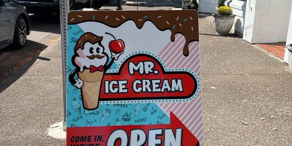 A sidewalk sign for Mr. Ice Cream Parlor.