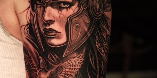 Tattoo of a warrior woman wearing an ancient helmet with an owl.
