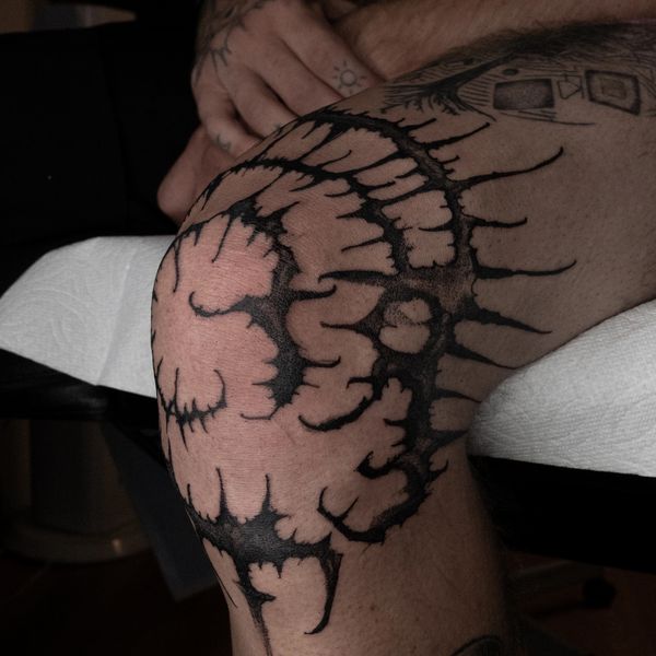 Close-up of a black geometric tattoo on a knee.