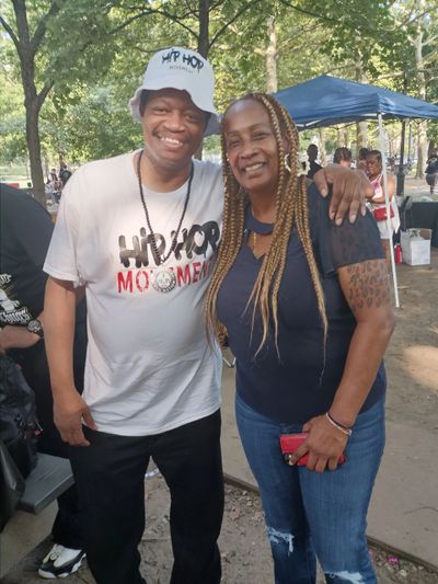 Two smiling friends posing together outdoors at a park event.