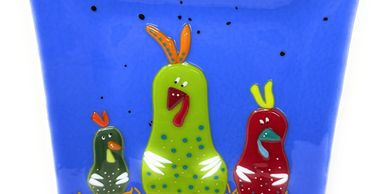 Fused glass blue plate featuring three colorful chickens.