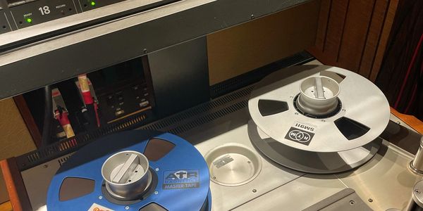 Two reel-to-reel tapes on a vintage audio machine.