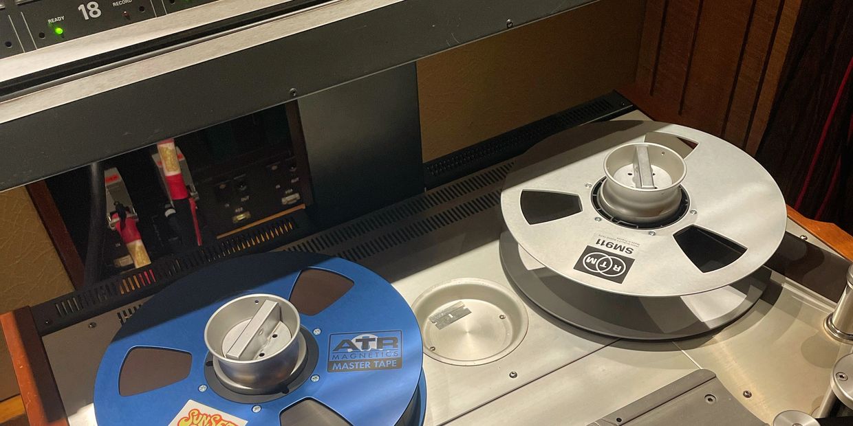 Two reel-to-reel tapes on a vintage audio machine.
