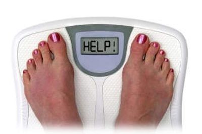 Feet standing on a scale. Instead of weight, the scale spells out HELP!