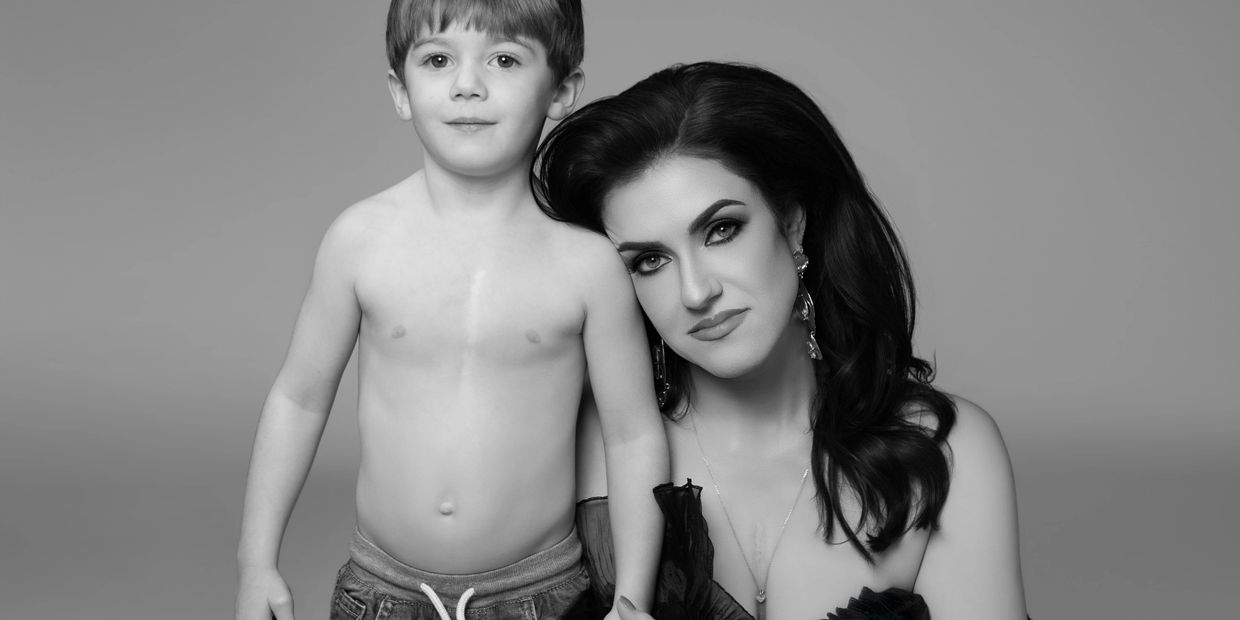 Black and white portrait of a woman and a young boy posing together.