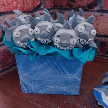 Cute shark-themed decorated treats in a blue box.