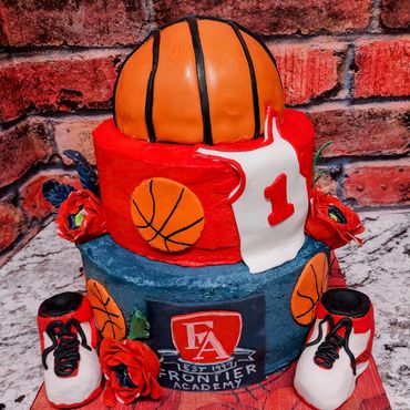 Two-tier basketball-themed cake with shoes and jersey.