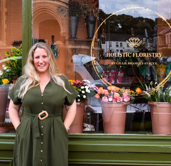 Lillie Bramley-Stacey standing in front of the Holistic Floristry shopfront. 