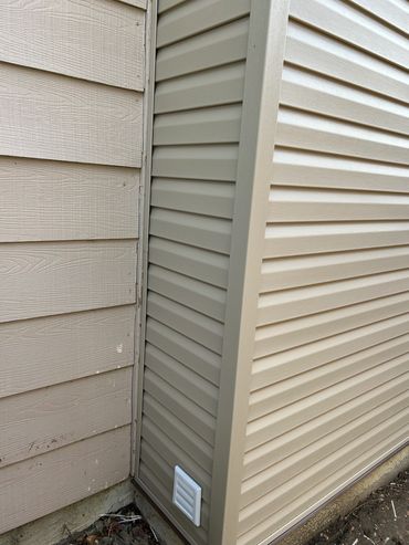 Close-up of two different siding types meeting at a house corner.
