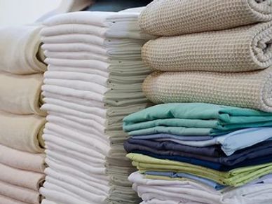 Neatly folded towels and clothes stacked in piles.