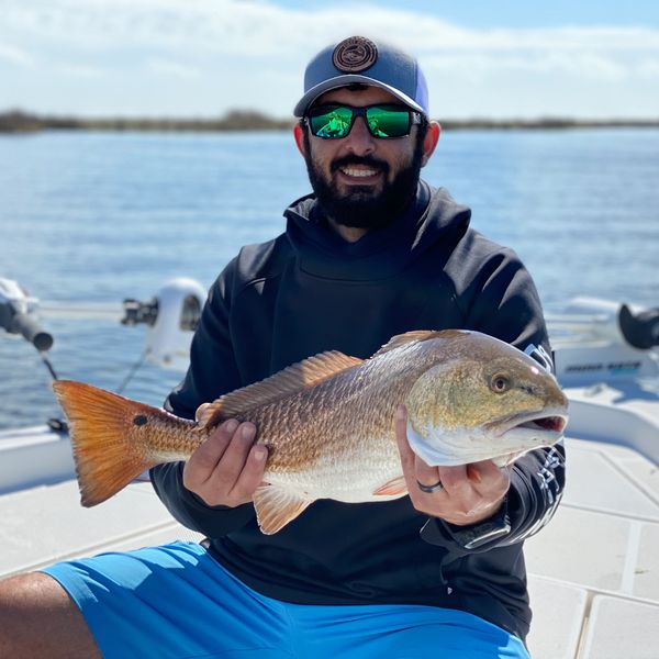Man holding a redfish (red drum) in St. Bernard, LA.