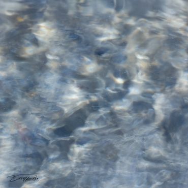 Abstract blue and white textured pattern resembling water or clouds.
