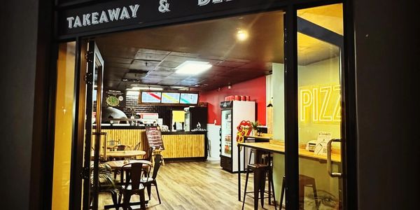 Entrance of a pizza restaurant called Firecraft Pizza.