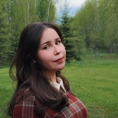 Young woman with long hair outdoors in a green natural setting.