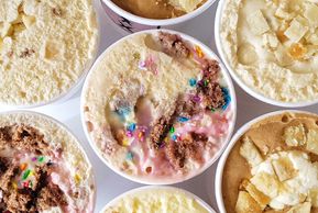 Assorted ice cream cups with toppings.