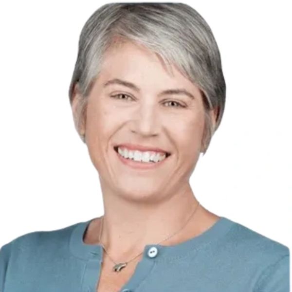 Smiling woman with short gray hair and blue top.
