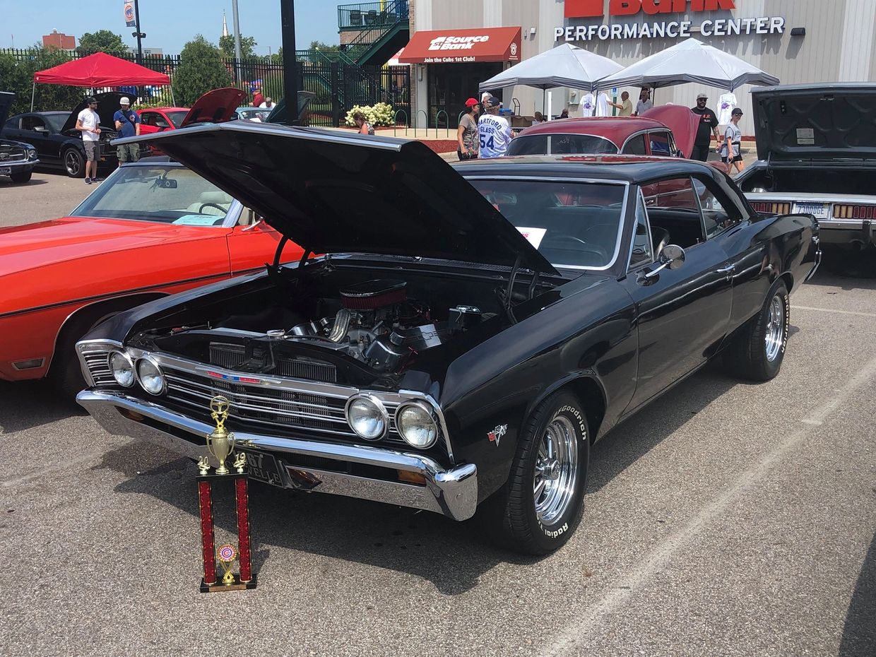 A trophy winning black muscle car on display at a car show.