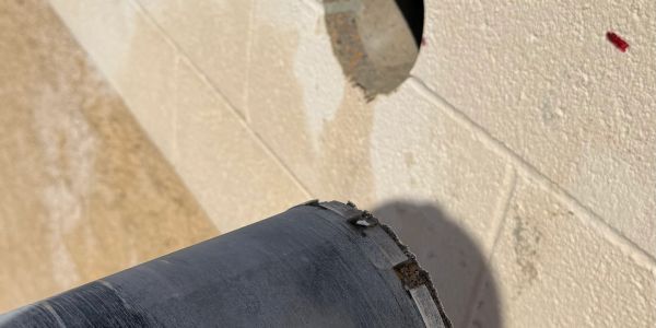 Concrete core drill cutting a clean opening through a wall