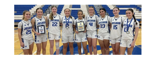 Girls basketball team in white uniforms posing with awards on gym floor.