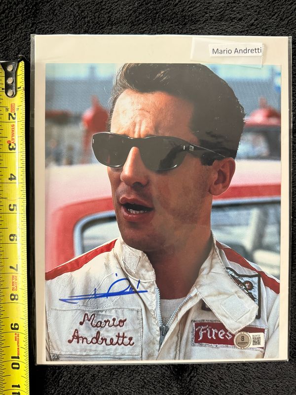 Signed photo of Mario Andretti in racing gear.