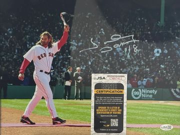 Autographed baseball player in Red Sox uniform on field.