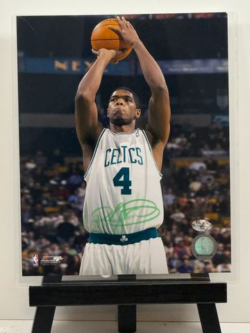 Basketball player in Celtics jersey shooting a free throw.
