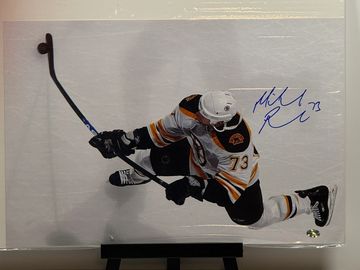 Hockey player in white and black jersey shooting puck.