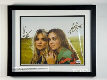 Framed signed photo of two women with description text.