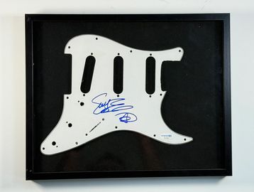 Framed, autographed guitar pickguard.