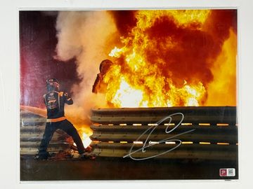 Medical delegate battling a huge fire near a racetrack barrier.