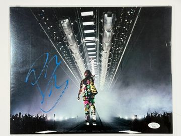 Performer on stage with a signed photo.