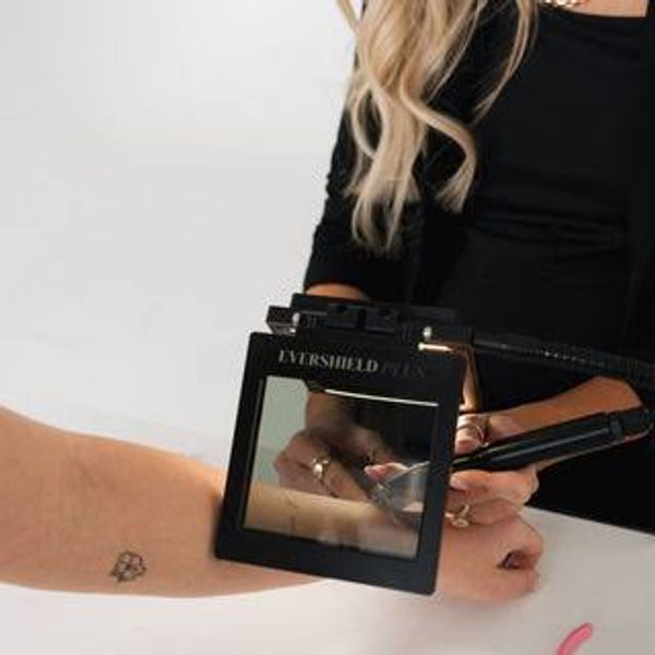 Device examining a tattoo on an arm.