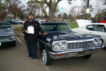 Classic car owner participates in Solanis, 707 Car and Bike Club collecting toys for children. 