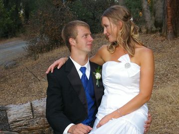 A bride sits quietly on her groom's lap for a tender moment after their wedding. El Dorado, CA
