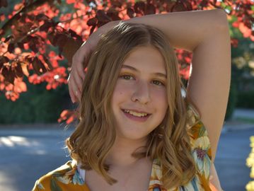 Freshman school portrait, bright fall leaves, lush greenery, golden hour photography