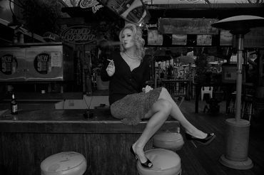 Woman smoking while sitting on top of the bar at the Powerhouse Pub in Folsom, California