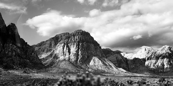 Black and white mountain landscape with clouds.
