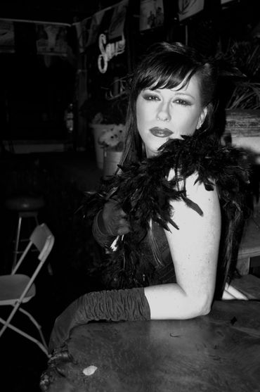 Intense seduction, vintage flapper awaits her beaux's arrival at the Old Scarlet Saloon.