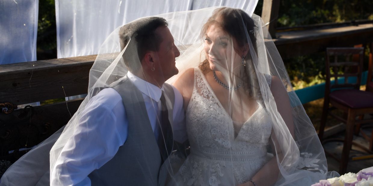 Bride and groom sharing a tender moment under the veil.