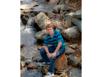 Young man, senior portraits, at the waterfalls in El Dorado Hills, California 