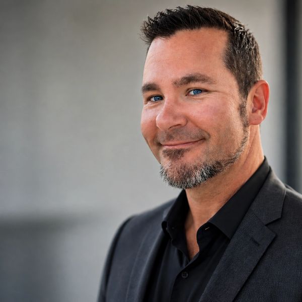 Confident man smiling in a suit jacket.