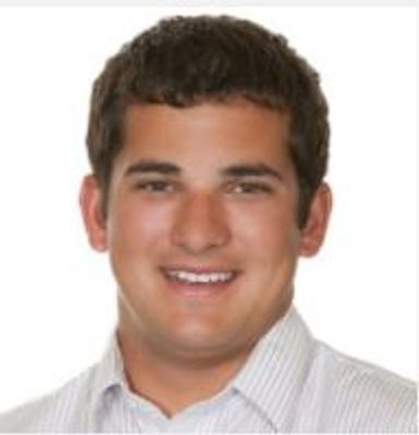 Portrait of a smiling young man with short dark hair.