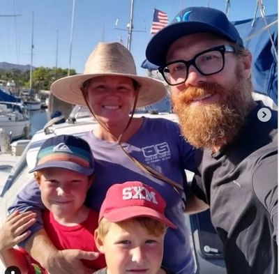 Family selfie at a marina on a sunny day.